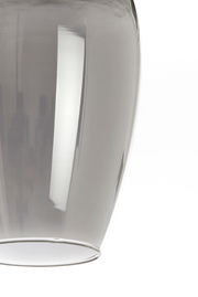 Nahaufnahme einer transparenten, gläsernen Hängeleuchte mit glatter Oberfläche, seitliche Perspektive.