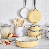 Kochgeschirr-Set Artizan 9-tlg in sanftem Gelb, bestehend aus Töpfen und Pfannen mit Glasdeckeln, präsentiert in einer modernen Küchenumgebung. Perspektive: Frontalansicht.