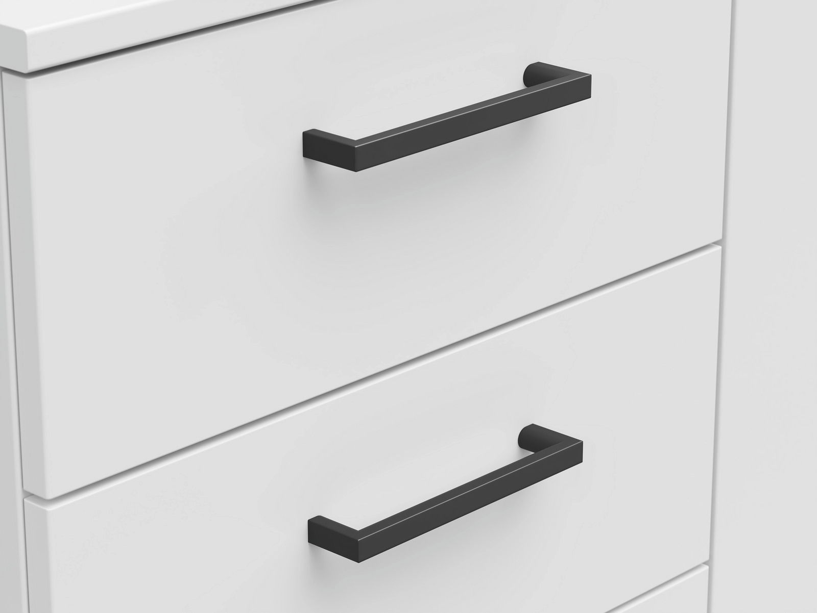 Nahaufnahme einer weißen Kommode mit schwarzen Griffen, seitliche Perspektive
