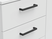 Nahaufnahme einer weißen Kommode mit schwarzen Griffen, seitliche Perspektive