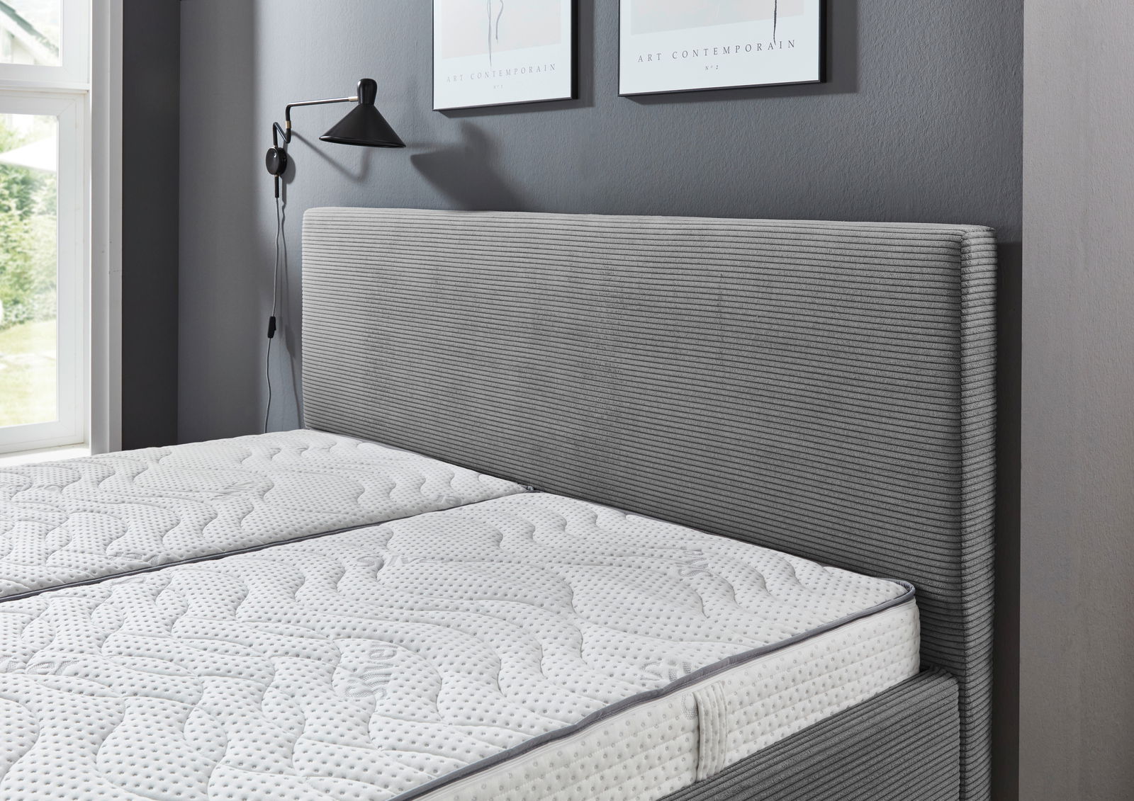 Graues Polsterbett 180x200 mit gestreiftem Kopfteil, seitliche Perspektive