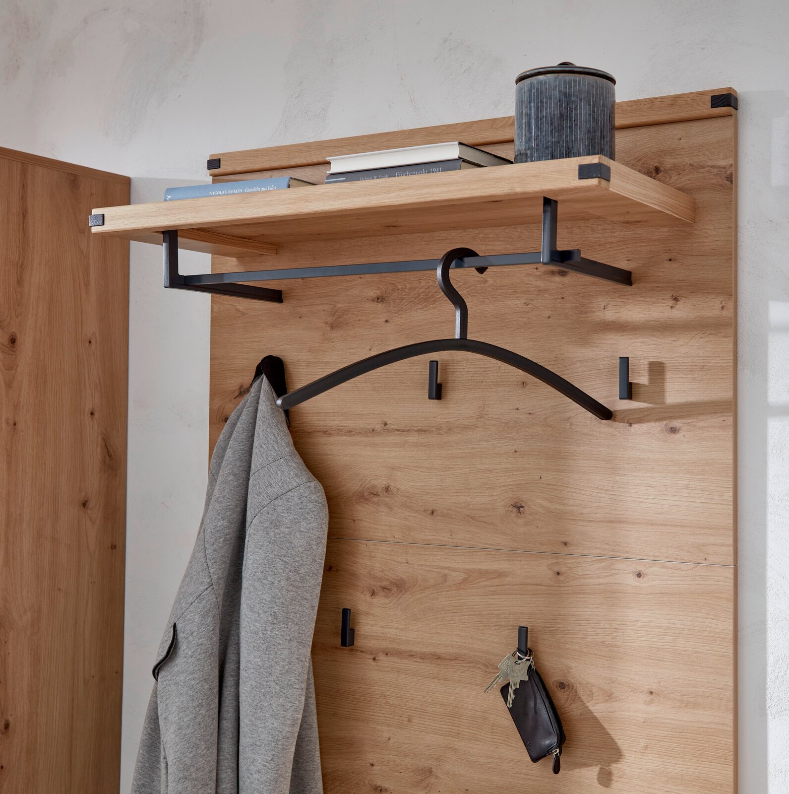 Garderobenpaneel aus Holz mit schwarzem Metallhaken, Kleiderbügel und Ablage, seitliche Perspektive