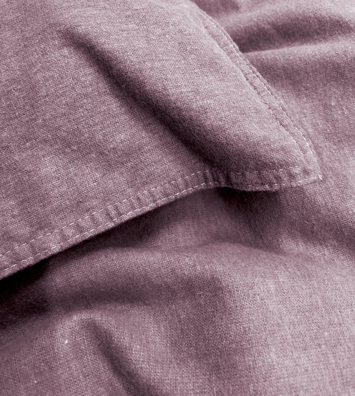 Nahaufnahme von lila Bettwäsche mit sichtbaren Nähten und weicher Textur