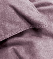 Nahaufnahme von lila Bettwäsche mit sichtbaren Nähten und weicher Textur