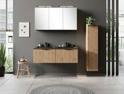 Modernes Waschtisch-Set 120 cm in Holzoptik mit schwarzer Arbeitsplatte, hängend an einer grauen Wand, mit Spiegel und Pflanzen, aus frontaler Perspektive.