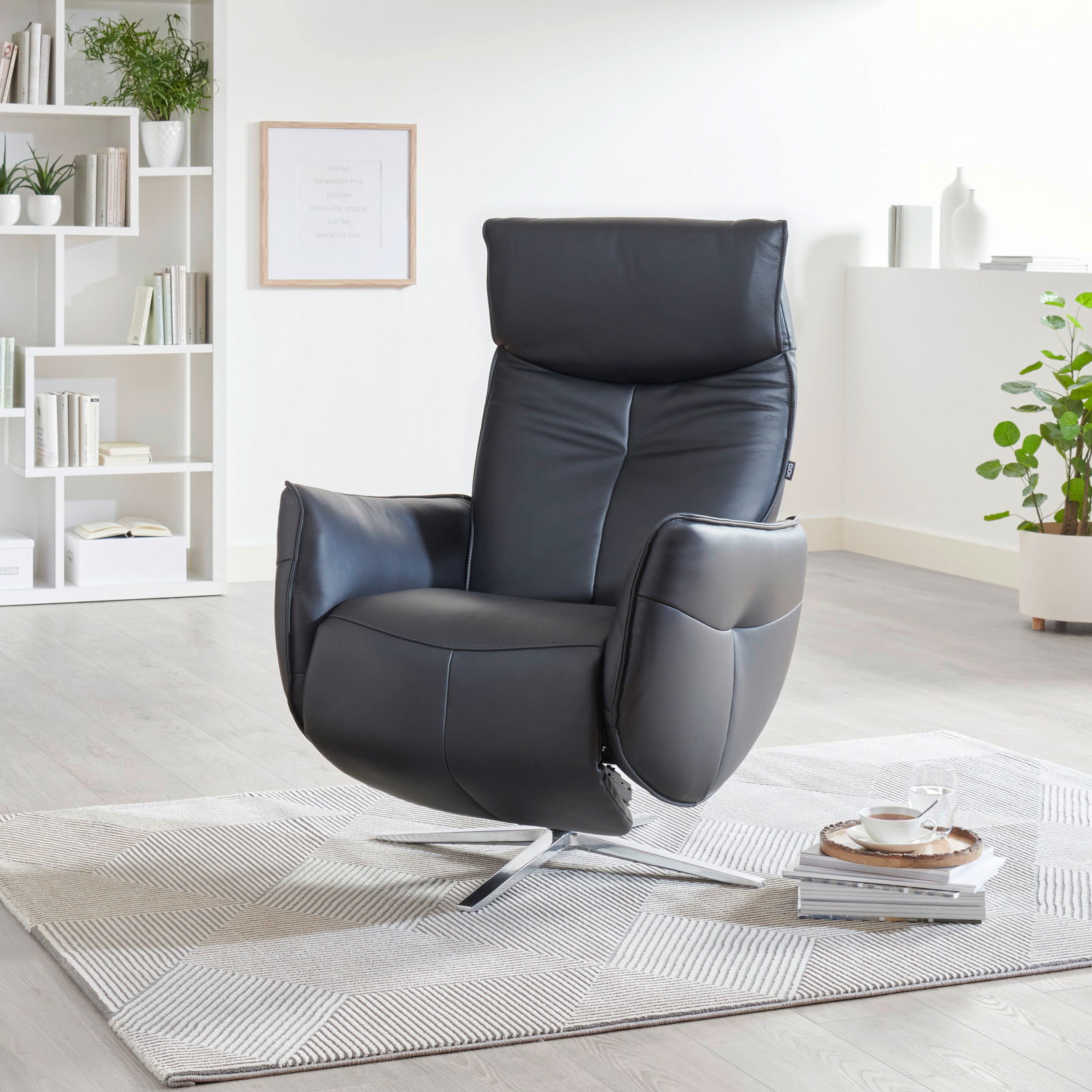 Moderner schwarzer Relaxsessel in einem hellen Wohnzimmer, seitliche Perspektive