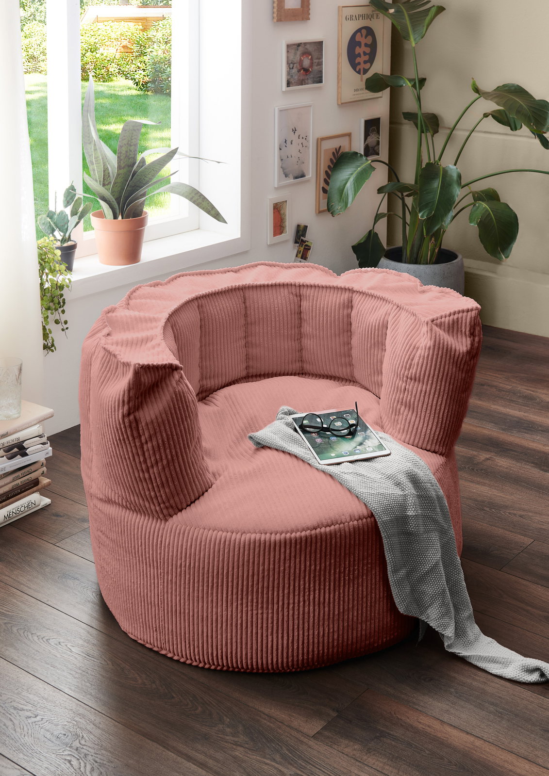 MID.YOU Sitzsack groß SNUGGLE Großer, rosafarbener Sitzsack in einem gemütlichen Wohnzimmer, umgeben von Pflanzen und Dekorationen, aus der Seitenperspektive fotografiert.