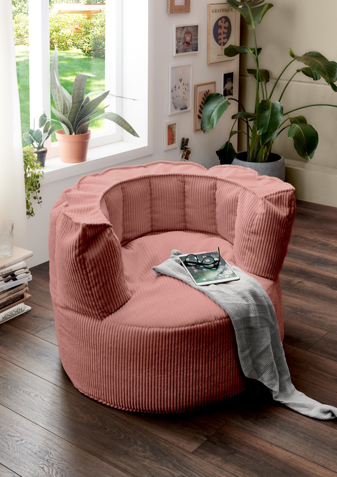 MID.YOU Sitzsack groß SNUGGLE Großer, rosafarbener Sitzsack in einem gemütlichen Wohnzimmer, umgeben von Pflanzen und Dekorationen, aus der Seitenperspektive fotografiert.