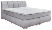 Graues Boxspringbett mit gestepptem Kopfteil, seitliche Perspektive