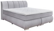 Graues Boxspringbett mit gestepptem Kopfteil, seitliche Perspektive