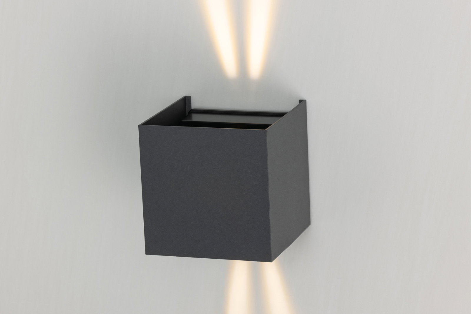 Moderne LED-Wandleuchte in schwarzem, kubischem Design mit Lichtstrahlen nach oben und unten, seitliche Perspektive