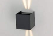 Moderne led-wandlamp in een zwart, kubistisch ontwerp met lichtstralen naar boven en beneden, zijaanzicht