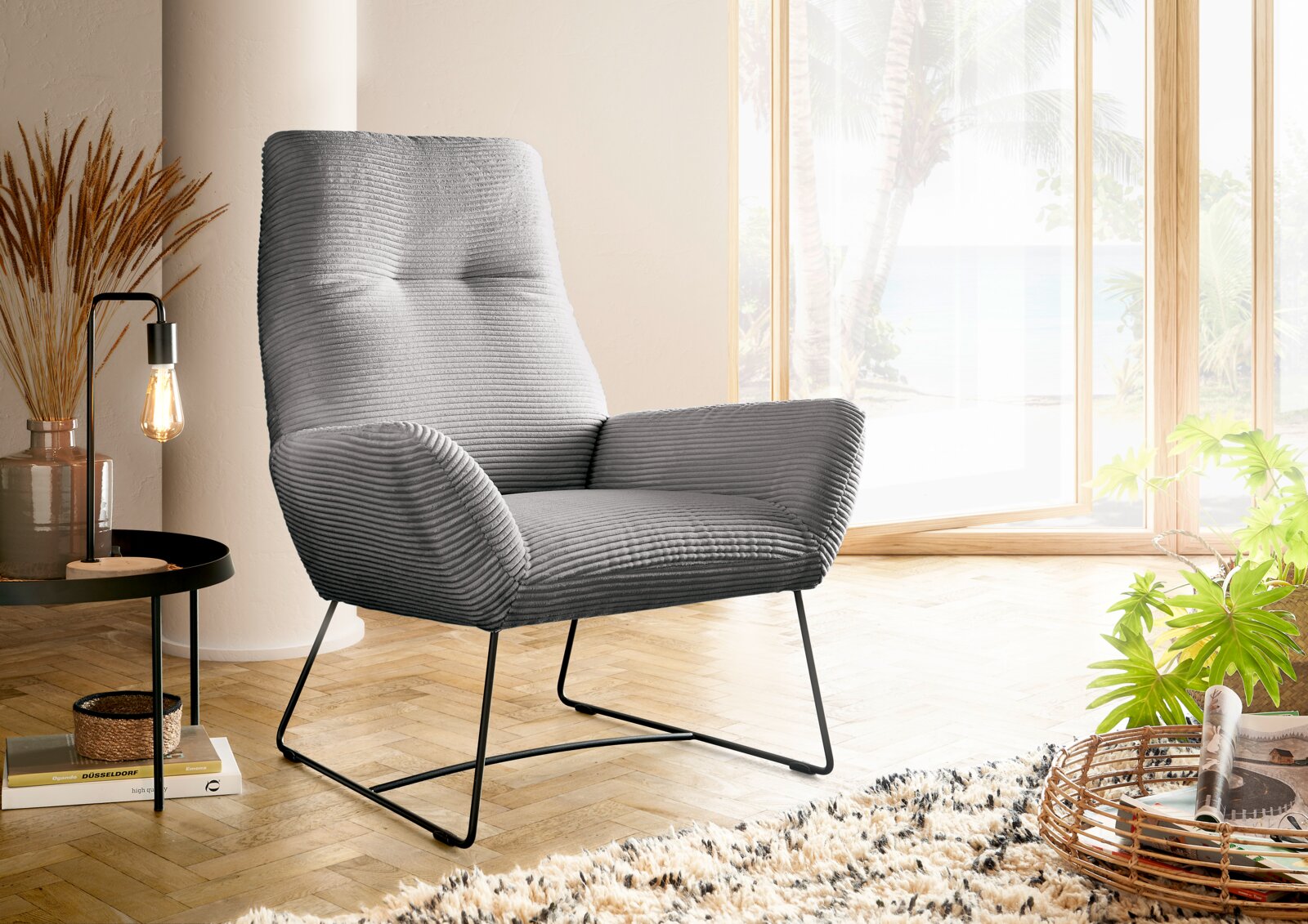 Lounge Handmade Sessel LH-BEN 2.0 Grauer Sessel mit geripptem Stoffbezug, seitliche Perspektive, in einem hellen Raum mit großen Fenstern und Holzboden.