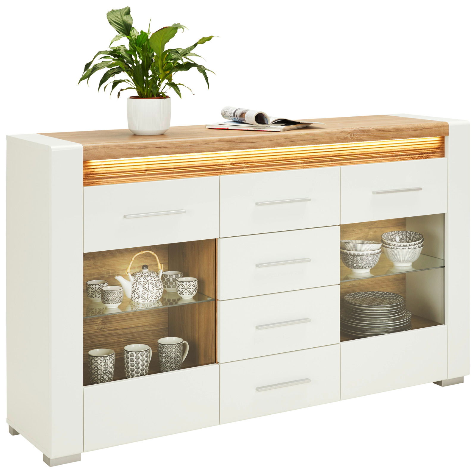 Modernes Sideboard mit weißem Korpus und Holzoberfläche, dekoriert mit einer Pflanze und Zeitschriften, aus frontaler Perspektive.