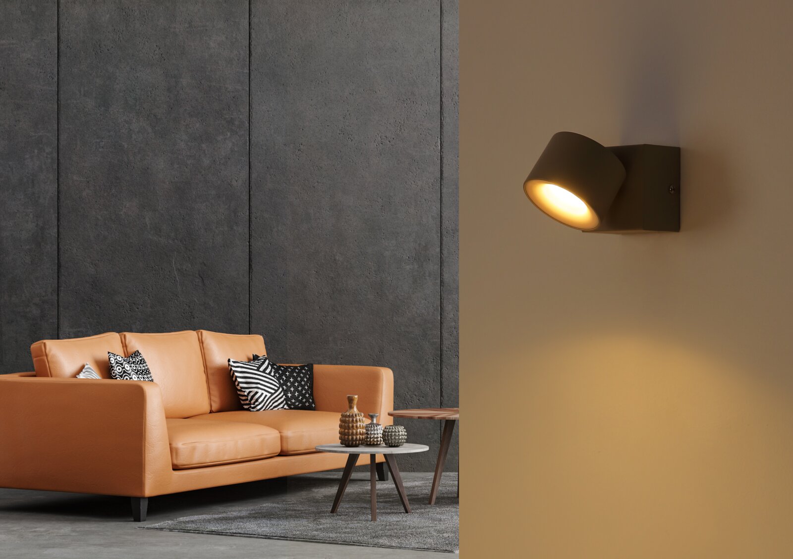 Moderne schwarze Wandleuchte mit zylindrischem Lampenkopf, warmem Lichtkegel nach unten, seitliche Wandmontage in Wohnraumszene Perspektive: seitliche Ansicht leicht von vorn.
