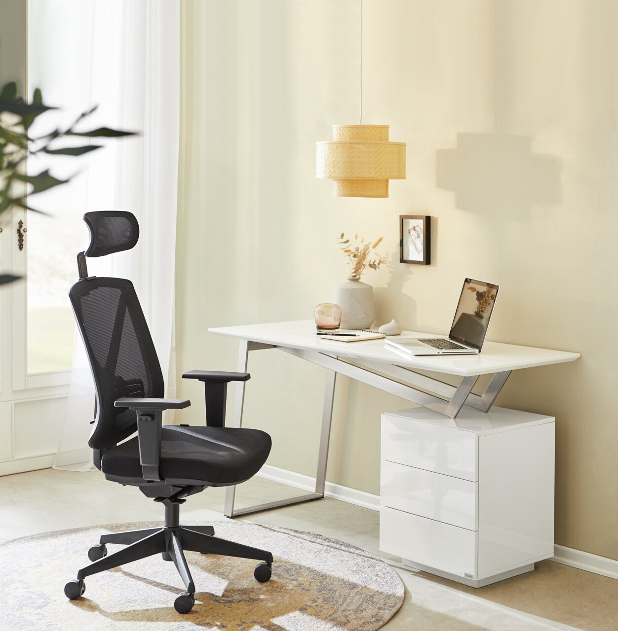 Moderner Schreibtisch in heller Umgebung mit ergonomischem Bürostuhl, seitliche Perspektive