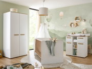 Helles Babyzimmer mit weißem Babybett mit Holzstäben, passendem weißen Kleiderschrank und Wickelkommode mit Holzgriffen vor grüner Heißluftballon-Wandtapete, fotografiert aus leicht schräger Frontperspektive.