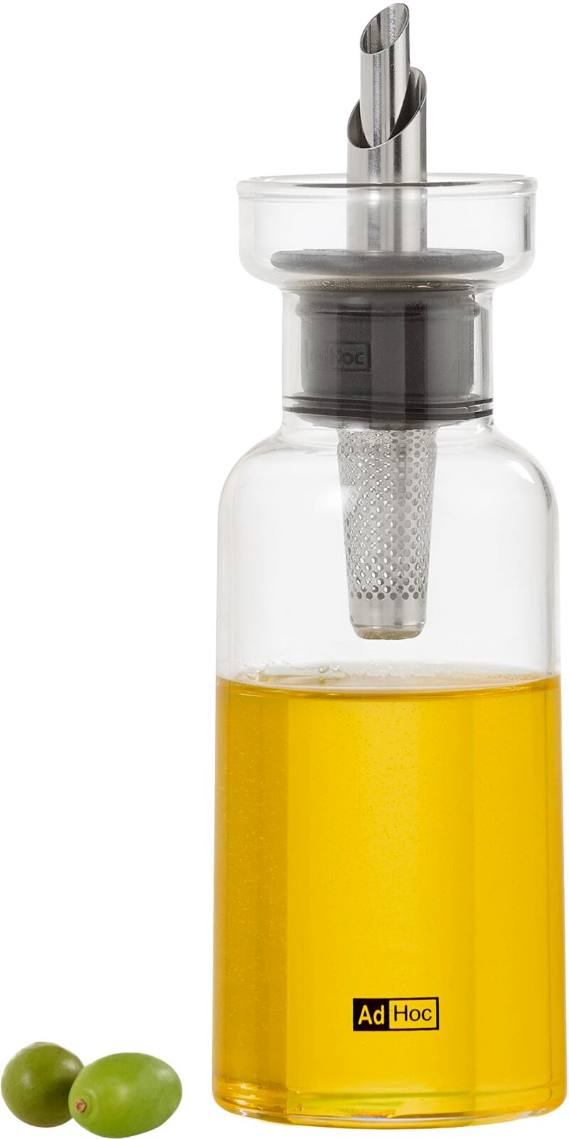 Transparente Glas-Ölflasche mit Edelstahlausgießer und integriertem Filter, gefüllt mit gelbem Öl, vorne in Frontalansicht; unten links zwei grüne Oliven auf weißem Hintergrund