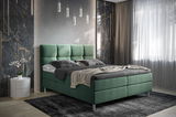 Grünes Boxbett in einem modernen Schlafzimmer mit eleganter Wandgestaltung und hängenden Lampen, seitliche Perspektive