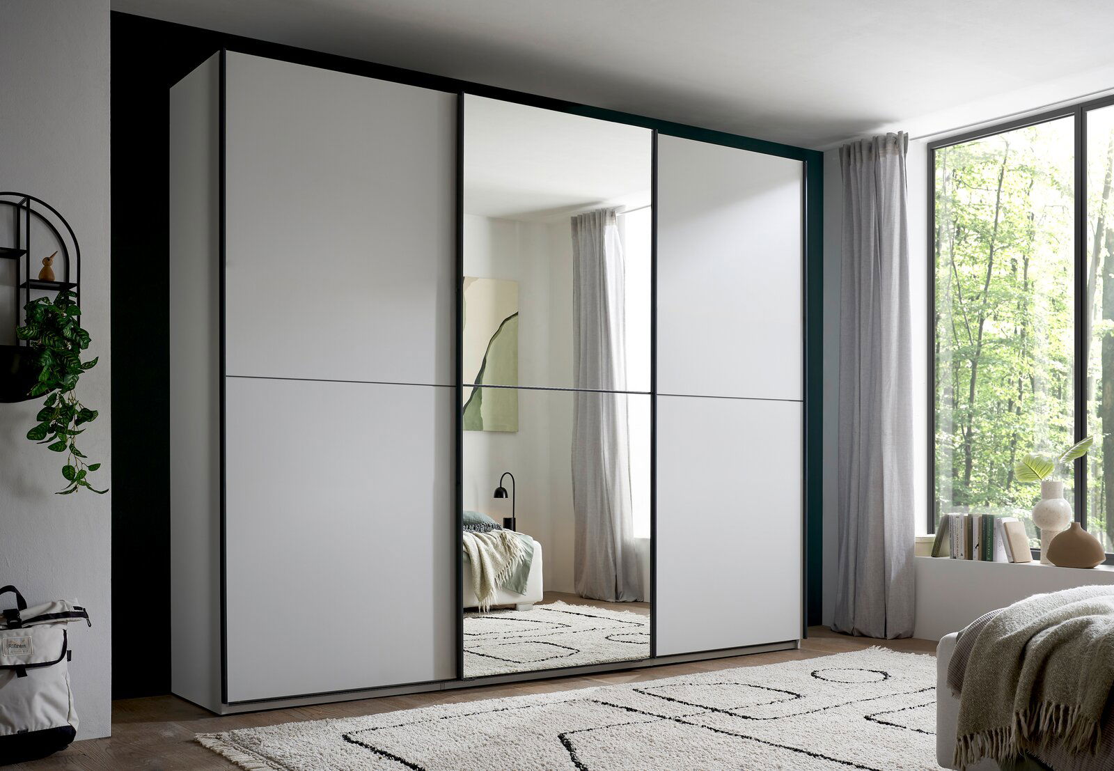 XORA Schwebetürenschrank 3-türig METRINO Moderner weißer Schwebetürenschrank mit mittlerer Spiegeltür im Schlafzimmer, Frontansicht aus leicht schräger Perspektive