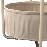 Close-up van een beige bijzettafeltje met een stoffen mand en een metalen onderstel.