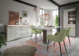 Moderne Esszimmer-Einrichtung mit Esstisch, grünen Stühlen und Sideboard in einem hellen Raum mit großen Fenstern, aus der Perspektive des Betrachters von vorne.