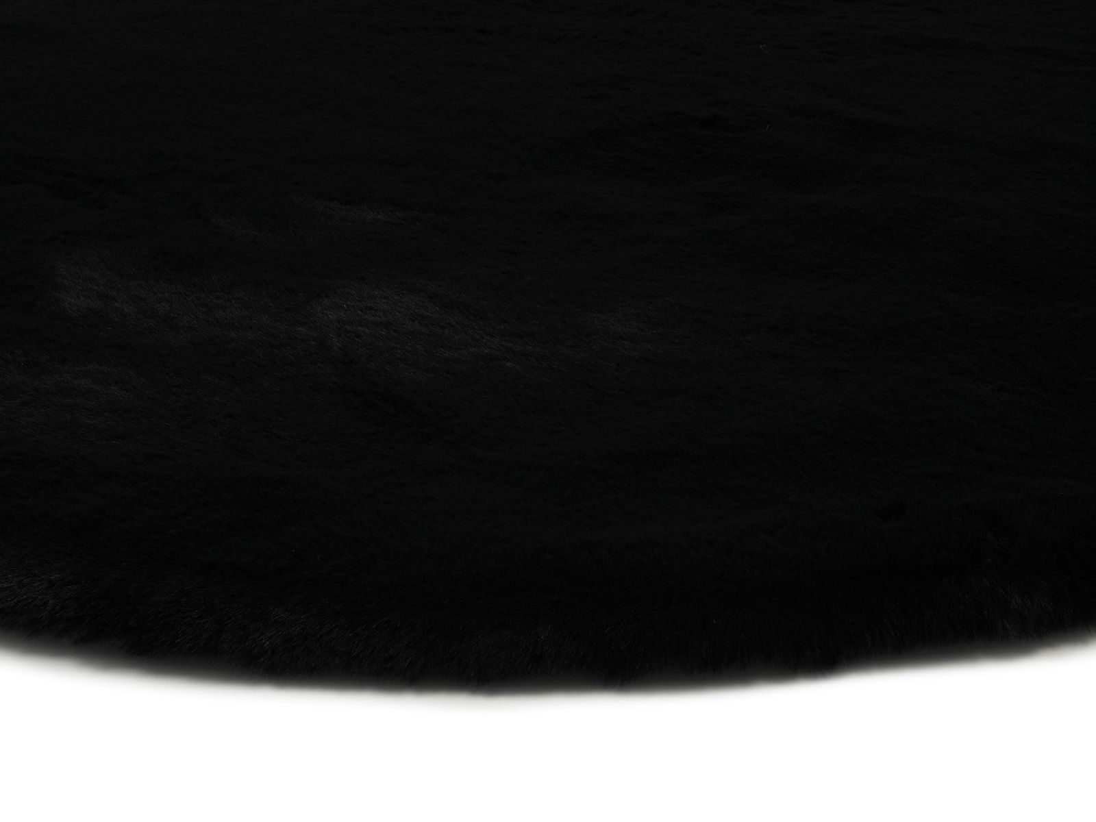 Nahaufnahme eines schwarzen Fellteppichs mit weicher Textur.