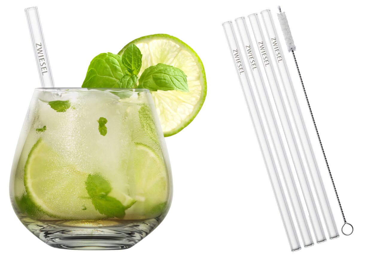 Close-up van een drankenset met glazen rietjes en een reinigingsborsteltje, inclusief een verfrissend drankje met limoen en munt in een glas.