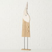 Holzfigur eines Gnomes mit spitzem Hut, frontal fotografiert vor einer weißen Ziegelwand.