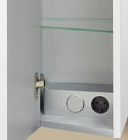 Innenansicht eines Badblocks mit geöffneter Tür, Glasablage und integrierter Steckdose.