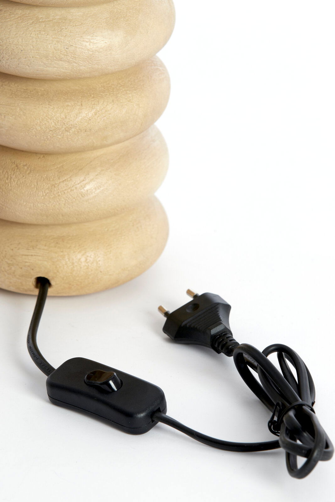 Nahaufnahme eines Lampenfußes aus hellem Holz mit einem schwarzen Kabel und Schalter, seitliche Perspektive.