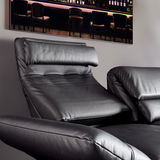 Nahaufnahme eines schwarzen Ledersofas mit verstellbarer Rückenlehne und Armlehnen, seitliche Perspektive.