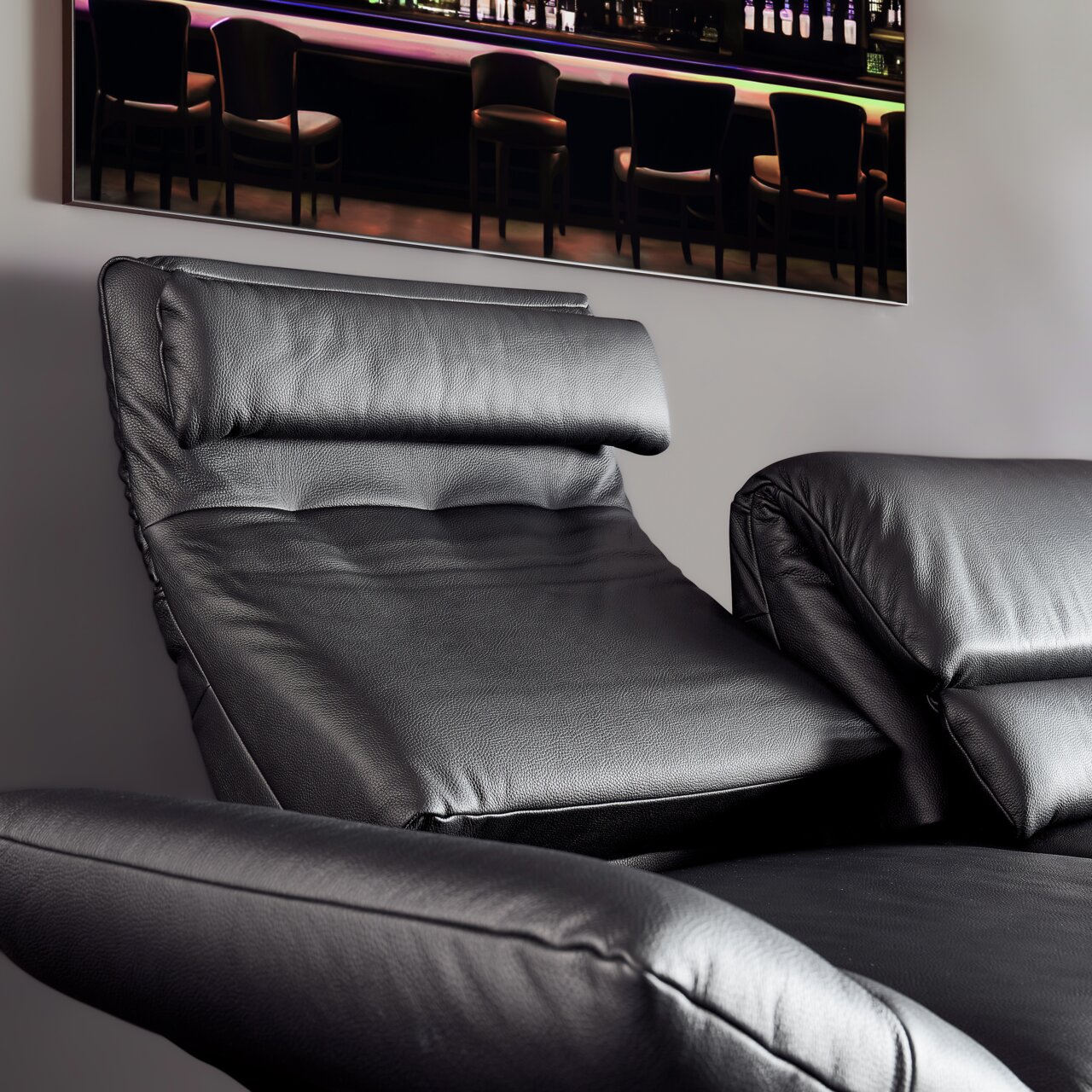 Nahaufnahme eines schwarzen Ledersofas mit verstellbarer Rückenlehne und Armlehnen, seitliche Perspektive.