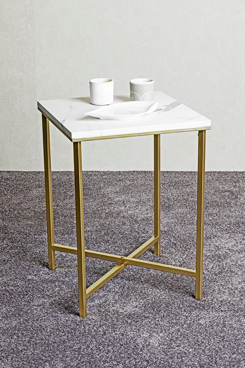Quadratischer Beistelltisch mit weißer Marmoroptik-Tischplatte und goldfarbenem Metallgestell, mit zwei weißen Bechern und einer Schale auf der Platte, fotografiert in leichter Schrägansicht von vorne oben.