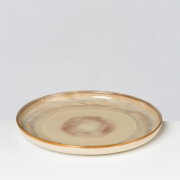 Runder Keramik-Speiseteller in Beige mit braun gesprenkelter Glasur und braunem Rand, freigestellt vor hellem Hintergrund, in leichter Draufsicht (3/4-Perspektive)