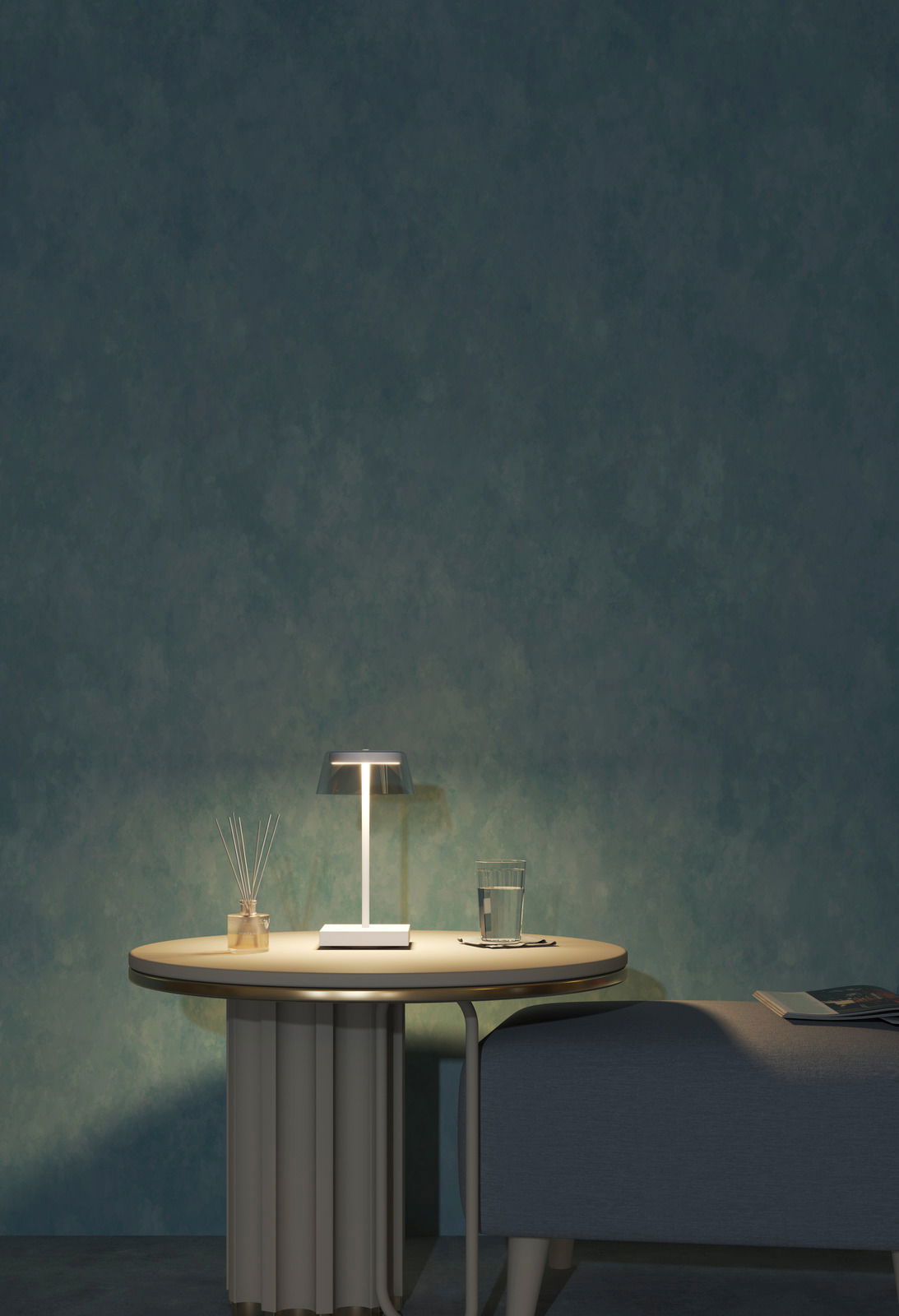 Moderne Akku-Tischleuchte auf einem runden Tisch, seitliche Perspektive, mit einem Glas Wasser und einem Duftstäbchen-Set daneben.