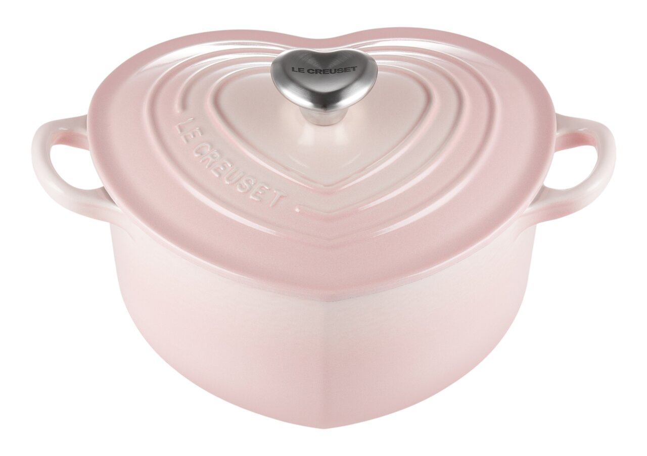 LE CREUSET Herzbräter pink 20 cm HEART COLLECTION Herzförmiger Bräter in zartem Rosa mit Deckel und zwei Griffen, von schräg oben fotografiert.