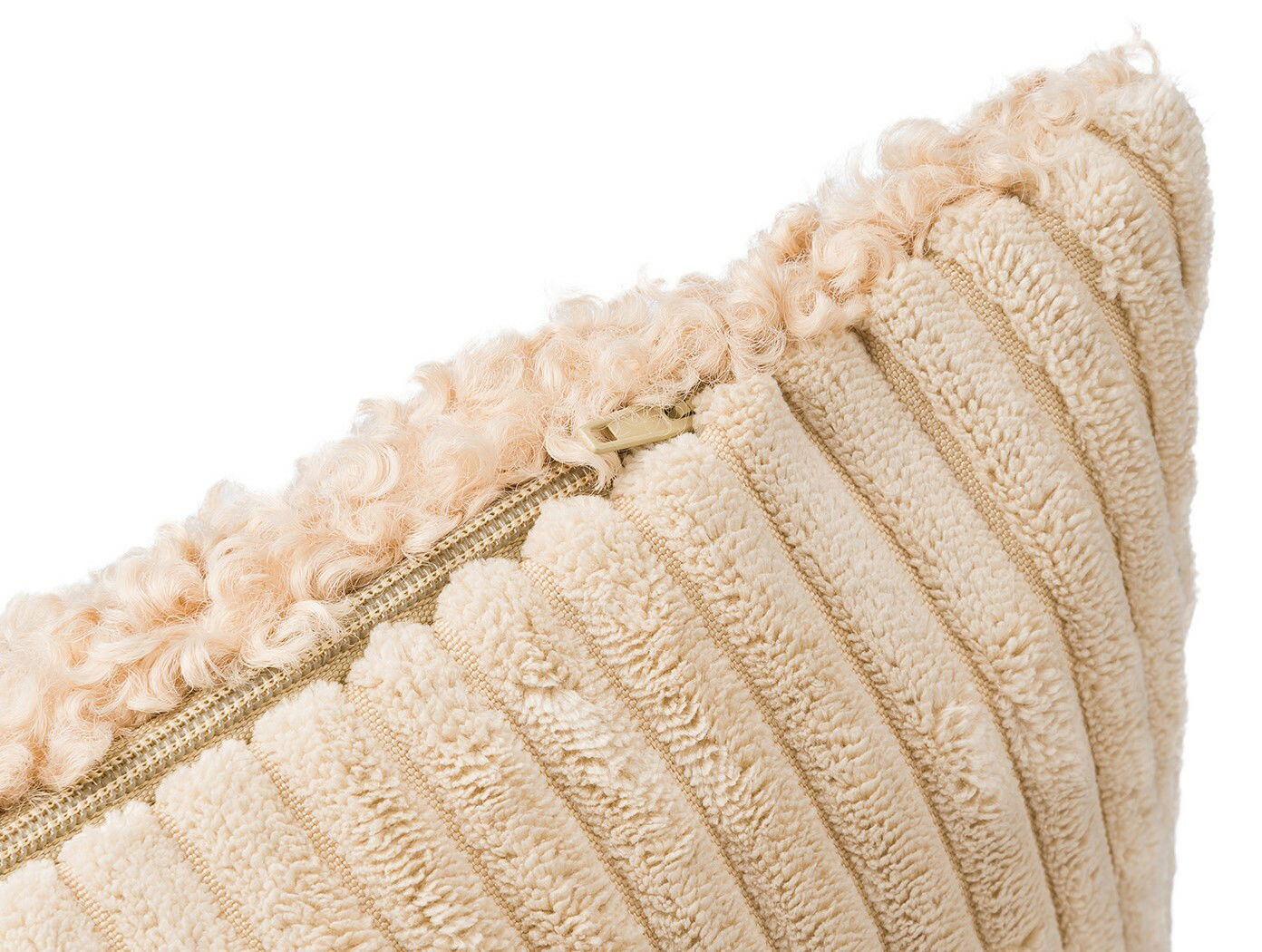 Nahaufnahme einer beigen Kissenhülle mit flauschiger Struktur und Reißverschluss, seitliche Perspektive.