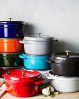 Verschiedene bunte Bräter Cocotte 24cm rund, gestapelt in einer seitlichen Perspektive.