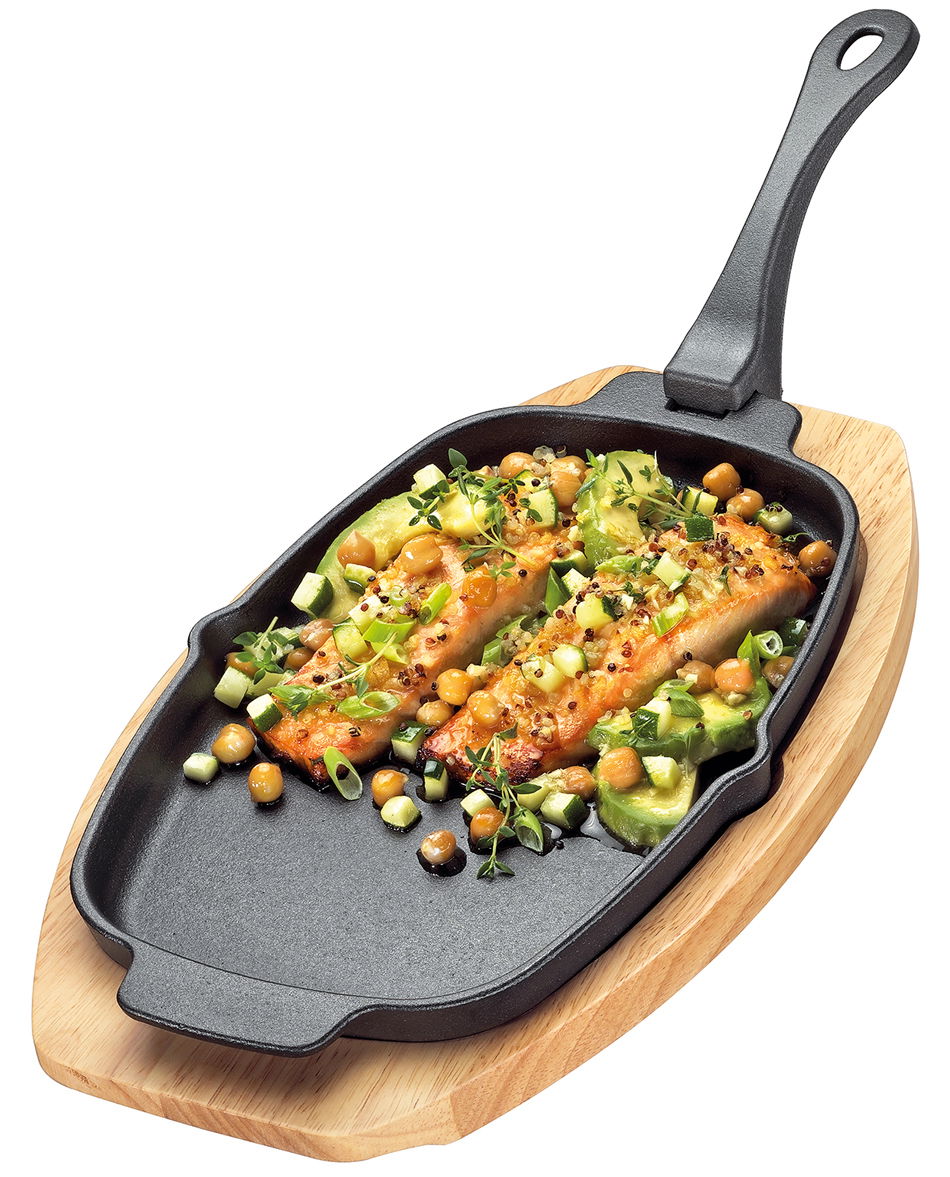 Servierpfanne mit abnehmbarem Griff, gefüllt mit gebratenem Lachs und Gemüse, auf einem Holzbrett, aus der Vogelperspektive