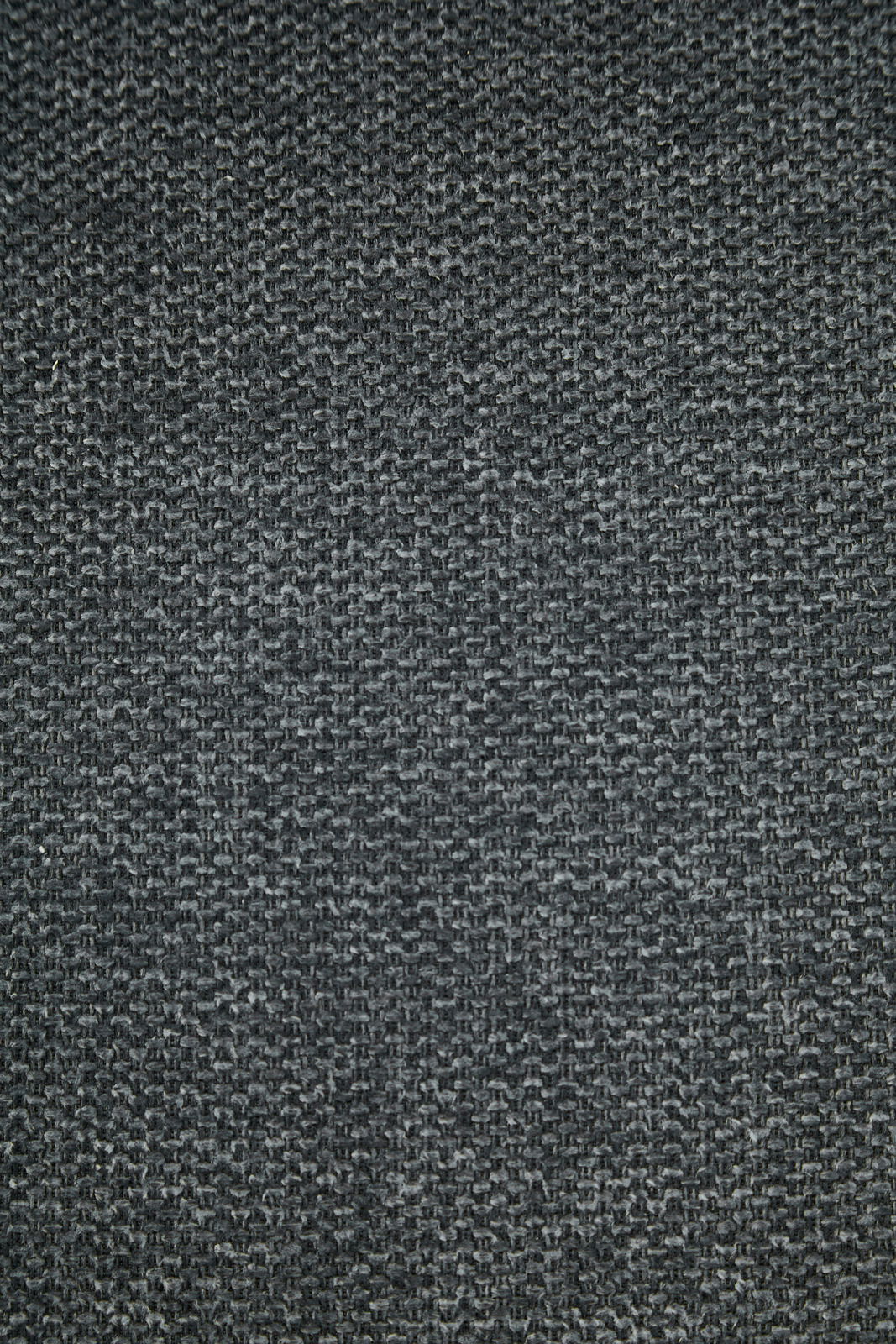 Nahaufnahme eines dunkelgrauen Stoffes mit grober Webstruktur, von oben betrachtet.