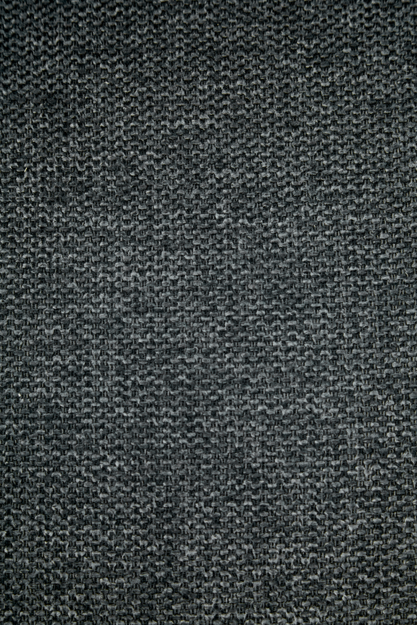 Nahaufnahme eines dunkelgrauen Stoffes mit grober Webstruktur, von oben betrachtet.