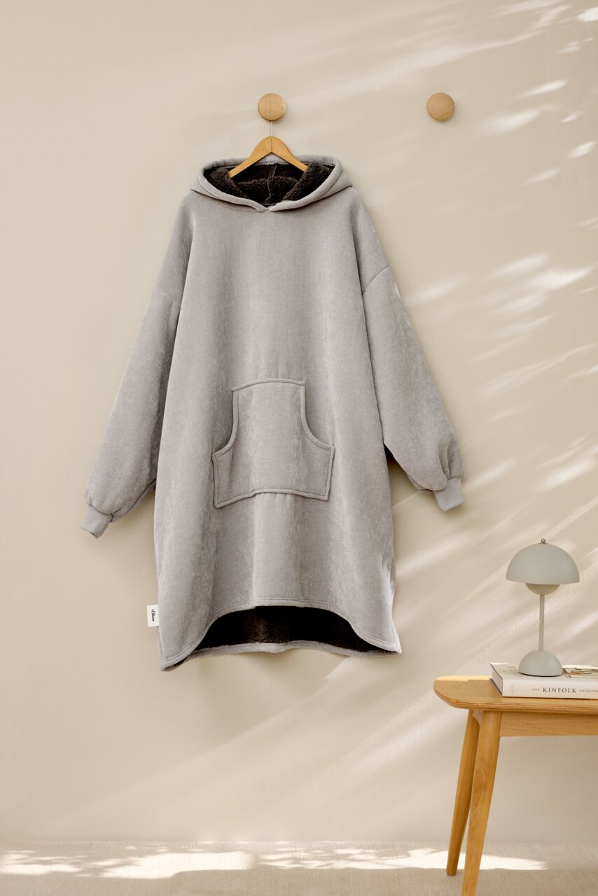 s.Oliver Lounge Hoodie Grauer Lounge Hoodie mit Kapuze und Kängurutasche, frontal an einem Haken hängend, mit weichem Innenfutter.