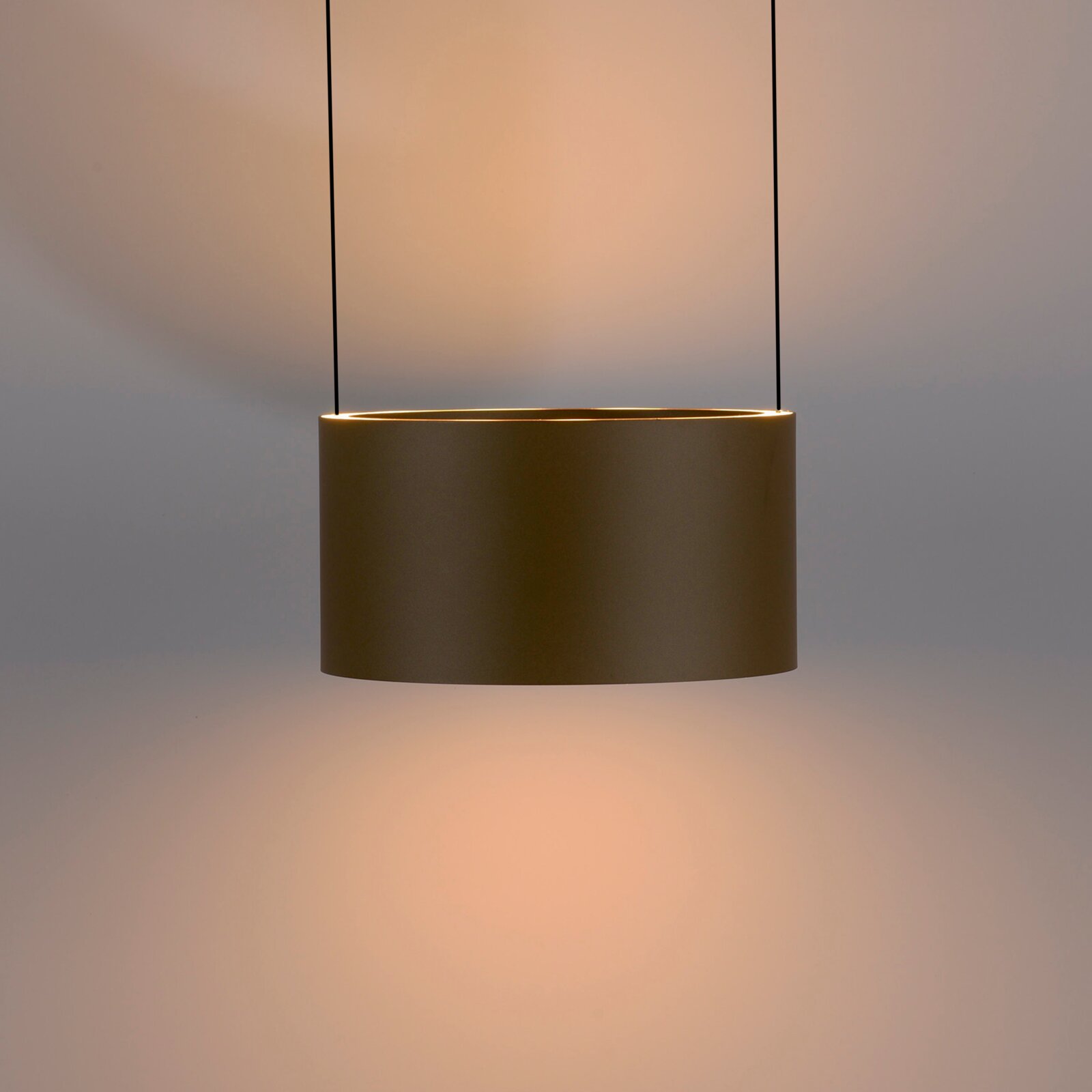 Moderne LED-Pendelleuchte in zylindrischer Form, seitliche Perspektive, warmes Licht abstrahlend