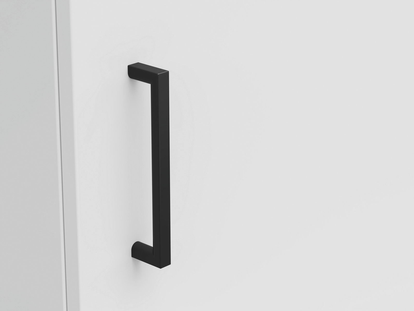 Nahaufnahme eines schwarzen, modernen Griffs an einer weißen Kommodentür, seitliche Perspektive