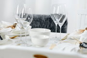 Elegante Müsli-Schale Skagen 15cm auf einem stilvoll gedeckten Tisch, umgeben von Weingläsern und weißem Geschirr, aus seitlicher Perspektive.
