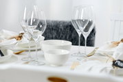 Elegante Müsli-Schale Skagen 15cm auf einem stilvoll gedeckten Tisch, umgeben von Weingläsern und weißem Geschirr, aus seitlicher Perspektive.
