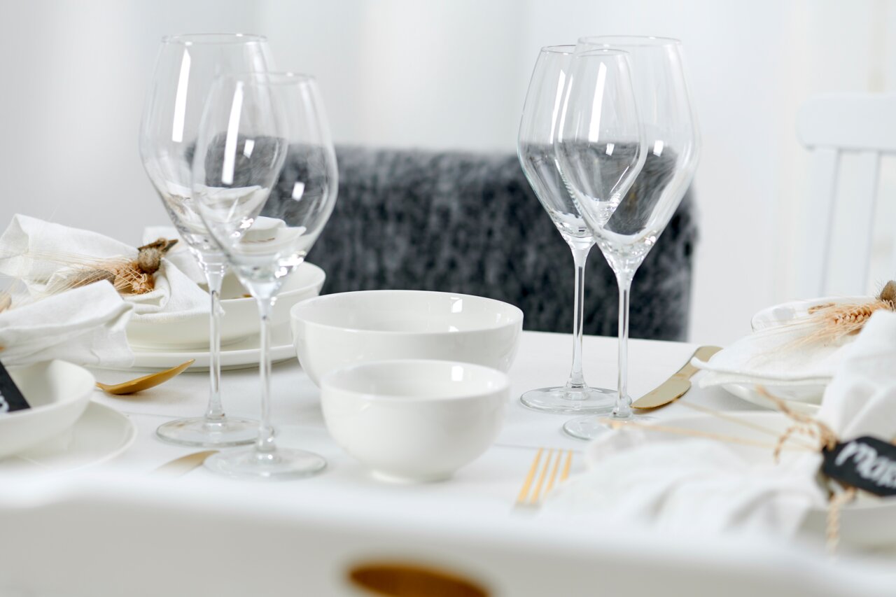 Elegante Müsli-Schale Skagen 15cm auf einem stilvoll gedeckten Tisch, umgeben von Weingläsern und weißem Geschirr, aus seitlicher Perspektive.