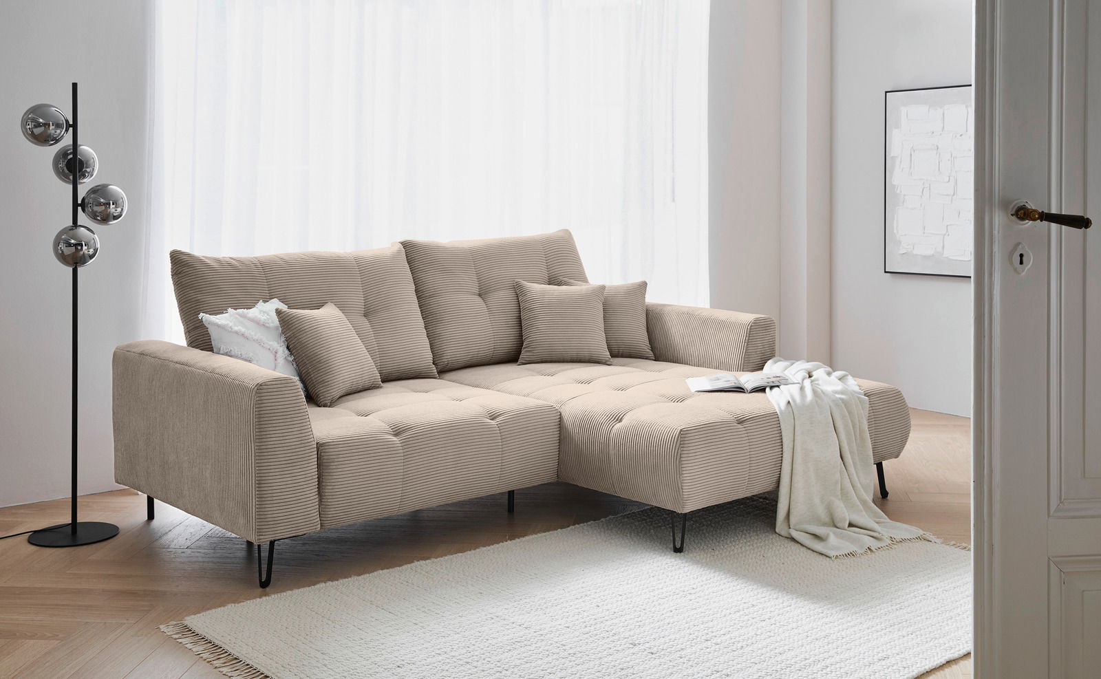 Beige Ecksofa mit Ottomane rechts, moderne Wohnzimmerumgebung, seitliche Perspektive