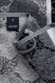 Grijze handdoek met ingeweven patroon en JOOP!-label, close-up